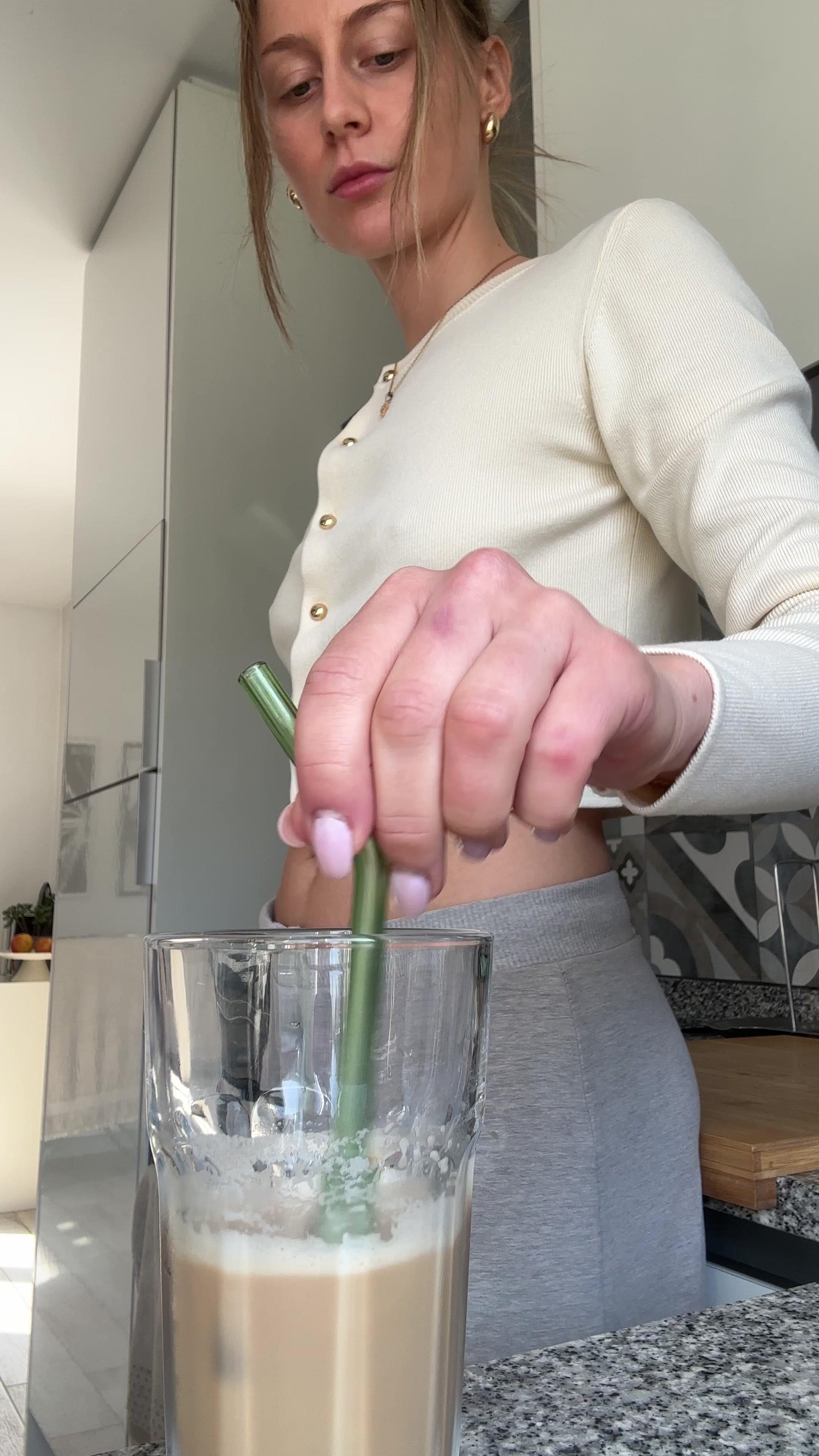 Woman Stirring and Sipping Iced Coffee