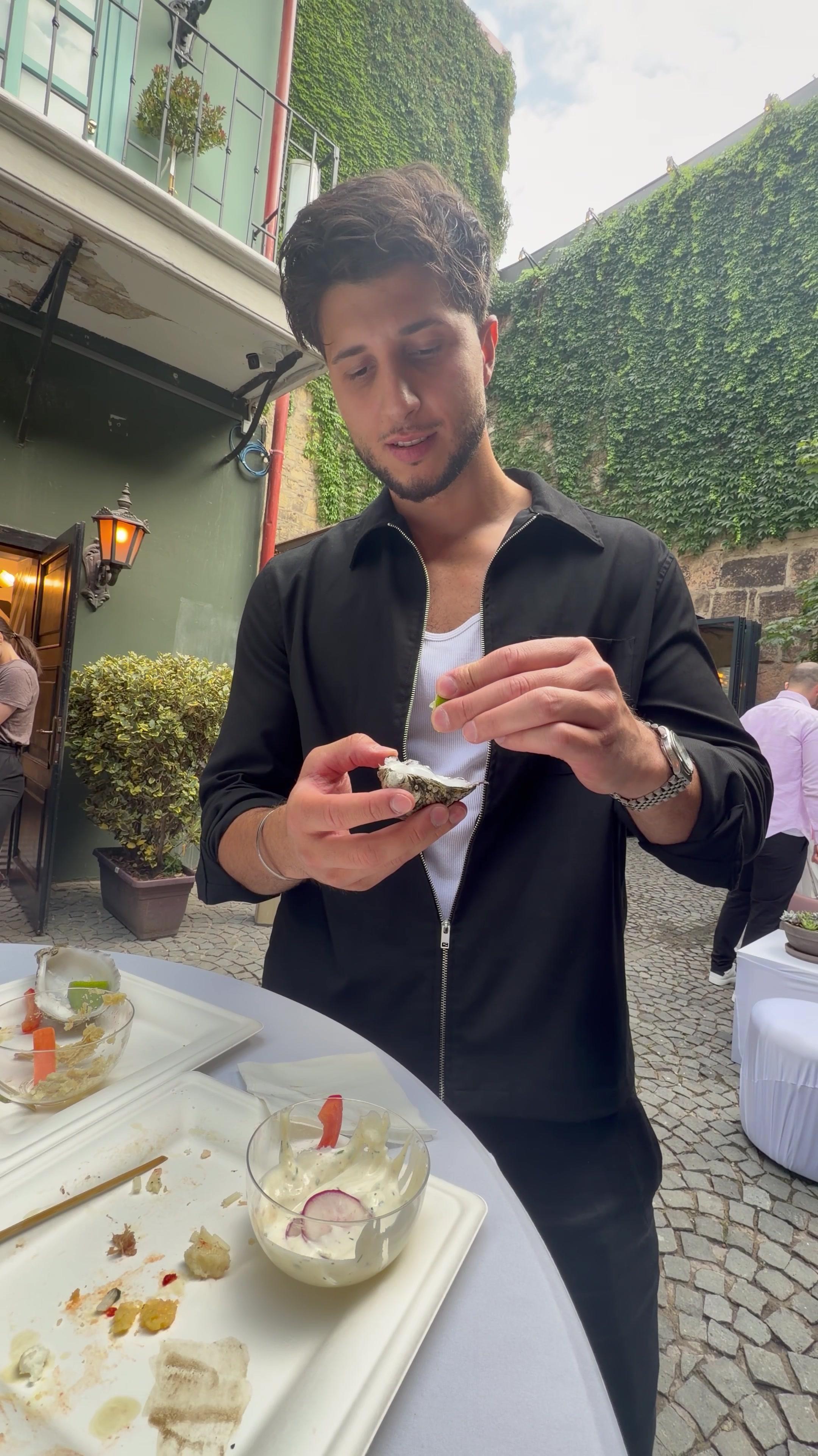 Young Man Eating Fresh Oyster Outdoors